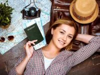 Junge Frau mit Reisepass und Landkarten