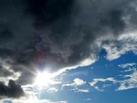 Dramatische Wolkenformation mit Sonne und blauem Himmel