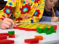 Kind spielt mit geometrischen Spielsteinen