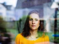 Mutter schaut aus dem Fenster in den Garten