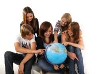 Gruppe von Schüler*innen umsteht einen Globus