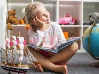 Kleines Mädchen träumt beim Lesen