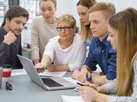 Gruppe junger Menschen um einen Laptop