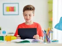 Foto eines Jungen beim Lernen mit Tablet