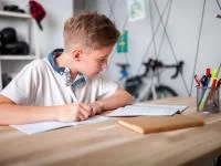 Ein Junge sitzt am Schreibtisch und lernt