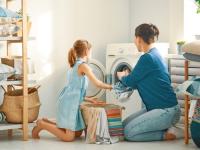 Mutter und Kind beim Wäsche machen