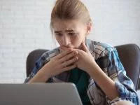 Ein schockiertes Mädchen vor dem Laptop