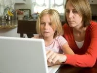 Frau und Kind sitzen gemeinsam vor Laptop