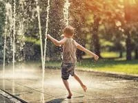 Foto eines spielenden Kindes im Springbrunnen